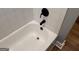 White tub and shower with black fixtures and white tiling at 1771 Ware Ave, East Point, GA 30344