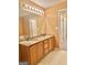 Bathroom showcasing a double sink vanity with wood cabinets and a large mirror at 2567 Laurel Nw Cir, Atlanta, GA 30311