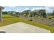 Spacious backyard with a large concrete patio, grassy area, and a view of neighboring homes at 361 Elkins Pl, Peachtree City, GA 30269