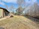 A large backyard with mature trees, a stream, and a swing set beyond the patio at 107 Stratford Ct, Peachtree City, GA 30269