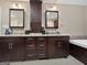 A bathroom featuring double sinks with dark cabinets, granite counters, and a jacuzzi tub at 107 Stratford Ct, Peachtree City, GA 30269