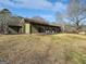 A rear view of a single-story home featuring green siding and several sliding glass doors at 107 Stratford Ct, Peachtree City, GA 30269