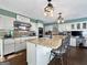 Well-lit kitchen with granite counters, stainless steel appliances, a breakfast bar, and hardwood floors at 107 Stratford Ct, Peachtree City, GA 30269