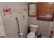Neutral bathroom featuring a toilet with a grab bar and floral decorations at 125 Oak Leaf Dr, Stockbridge, GA 30281