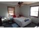 Cozy bedroom featuring a white bed frame, ceiling fan, and natural light from two windows at 125 Oak Leaf Dr, Stockbridge, GA 30281