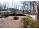 Quiet street bordered by mature trees with a light-colored ranch home in the background at 125 Oak Leaf Dr, Stockbridge, GA 30281