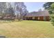 Open backyard area with brick house and lush greenery creates a serene outdoor space at 25 Brookstone Ct, Covington, GA 30016