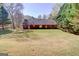 Large grassy backyard with a brick home and mature trees offering shade and privacy at 25 Brookstone Ct, Covington, GA 30016