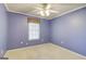 Bedroom with purple walls, carpet, and ceiling fan, offering a simple and cozy aesthetic at 25 Brookstone Ct, Covington, GA 30016