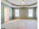 Main bedroom featuring neutral walls, tray ceiling with fan, and carpeted flooring with windows for ample light at 25 Brookstone Ct, Covington, GA 30016