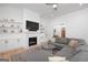 Comfortable living room with a fireplace, built-in shelves, and a large gray sectional sofa at 9770 Coleman Rd, Roswell, GA 30075