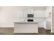 Bright, modern kitchen featuring white cabinetry, stainless steel appliances, quartz countertops, and dark wood floors at 313 Sound Cir # 140, Stockbridge, GA 30281