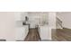 Bright kitchen features white cabinets, stainless appliances, island, and wood-look floors at 313 Sound Cir # 140, Stockbridge, GA 30281
