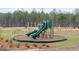 Community playground featuring modern play structures, soft turf, and a perimeter of natural landscaping at 313 Sound Cir # 140, Stockbridge, GA 30281