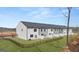 Exterior view of a row of townhomes with fenced backyards and manicured lawns at 313 Sound Cir # 140, Stockbridge, GA 30281