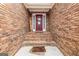 Brick entryway with red door and welcome mat at 443 Abbey Pl, Villa Rica, GA 30180