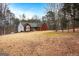 Red brick house with a large yard and mature trees in the front at 55 Rainey Ridge Dr, Oxford, GA 30054