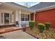 Covered front porch with rocking chairs and brick walkway at 55 Rainey Ridge Dr, Oxford, GA 30054