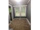 Simple dining room with gray walls, carpet, and two windows at 1178 King Rd, Riverdale, GA 30296