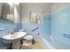 Bathroom with blue tile, bathtub, and pedestal sink at 241 Simon Ter, Atlanta, GA 30338