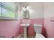 Small bathroom with pink tile and pedestal sink at 241 Simon Ter, Atlanta, GA 30338