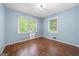 Blue-walled bedroom with wood floors and two windows at 241 Simon Ter, Atlanta, GA 30338