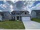 Two-story house with gray siding, a large front yard, and a two-car garage at 117 Oliver Dr, Locust Grove, GA 30248