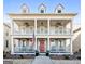 Elegant two-story home featuring double porches, classic columns, and a vibrant red door creating a welcoming facade at 112 Centennial Dr, Peachtree City, GA 30269