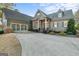 Green house with stone accents, two-car garage, and manicured lawn at 8445 Nolandwood Ln, Villa Rica, GA 30180