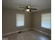 Bright bedroom with two windows, ceiling fan, and wood-look floors at 5157 West Nw St, Covington, GA 30014