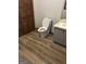 Bathroom with wood-grain flooring, white toilet and grey vanity at 5427 Forest Pines Dr, Lithonia, GA 30058