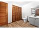 Neutral bathroom featuring a single sink vanity, wood look floor, and a set of closet doors at 5427 Forest Pines Dr, Lithonia, GA 30058