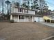 The exterior boasts a covered porch, two-car garage, and a chimney amidst mature trees at 5427 Forest Pines Dr, Lithonia, GA 30058