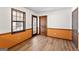 A cozy room featuring light wood laminate flooring, white and orange walls and natural light from a large window at 5427 Forest Pines Dr, Lithonia, GA 30058