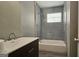 Bathroom with gray tile, tub, and dark vanity at 5173 Kingswood Cir, Atlanta, GA 30349