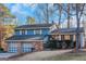 Ranch style home with brick and blue siding, two-car garage, and mature landscaping at 100 Traverse Ct, Atlanta, GA 30349