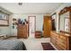 Spacious bedroom featuring ample wood furnishings, a floral wallpaper border, and access to the bathroom and hallway at 255 Barnett Road Rd, Hampton, GA 30228