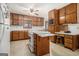 Traditional kitchen with wood cabinetry, white countertops, and an island with a built-in cooktop and fold-out extension at 255 Barnett Road Rd, Hampton, GA 30228