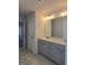 Bathroom with double sink vanity, gray cabinets, and neutral tile floors at 1455 Weeping Tree Cir, Auburn, GA 30011