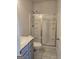 Bathroom with vanity, toilet, tile floors and glass enclosed shower with shelves at 1455 Weeping Tree Cir, Auburn, GA 30011
