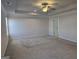 Main bedroom features neutral carpet flooring, a ceiling fan, and a walk-in closet at 1455 Weeping Tree Cir, Auburn, GA 30011