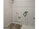 A functional laundry room featuring essential hookups, white walls, and durable gray flooring at 1455 Weeping Tree Cir, Auburn, GA 30011