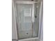 Shower stall featuring glass doors, built-in shelving, and chrome shower fixtures at 1455 Weeping Tree Cir, Auburn, GA 30011