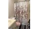 Bathroom featuring a floral shower curtain, sink, toilet, and a small patterned rug at 241 E Ash St, Social Circle, GA 30025