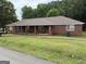 Exterior view of the single-story brick home with covered porch at 241 E Ash St, Social Circle, GA 30025