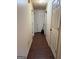 Hallway with multiple doors and neutral walls leads to various rooms in the home at 241 E Ash St, Social Circle, GA 30025