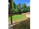 Fenced backyard with lush green grass and mature trees at 65 Waters Edge Ln, Covington, GA 30014