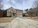 Beautiful two-story brick home with a two-car garage and manicured landscaping under a cloudy sky at 65 Waters Edge Ln, Covington, GA 30014