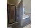 Bathroom features a tile shower and soaking tub with stylish bronze shower door at 65 Waters Edge Ln, Covington, GA 30014