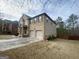 Side view of a brick home with a two-car garage and well-maintained lawn at 65 Waters Edge Ln, Covington, GA 30014
